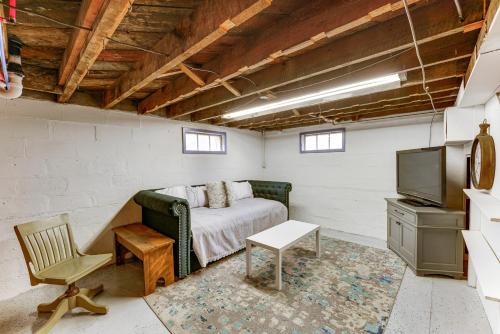 Un dormitorio con una cama, un televisor y una silla. en Quiet Manistee Home with Patio Less Than 1 Mi to Beaches!, en Manistee