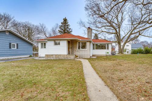 Casa blanca con techo rojo y patio en Quiet Manistee Home with Patio Less Than 1 Mi to Beaches!, en Manistee