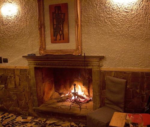a fire in a fireplace in a room with a chair at La Bussola Da Gino in Quarrata