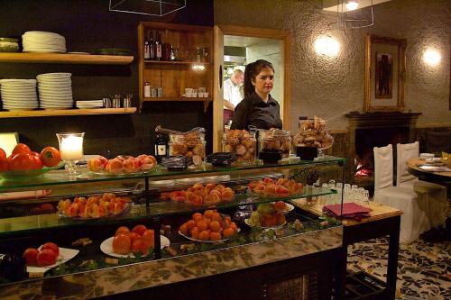 a woman standing behind a counter with a buffet of food at La Bussola Da Gino in Quarrata