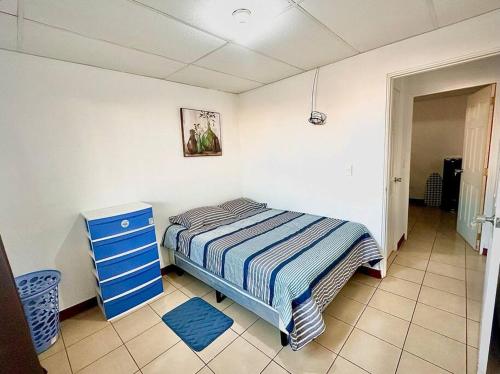 1 dormitorio con 1 cama y vestidor azul en Hidden Gem, en Managua