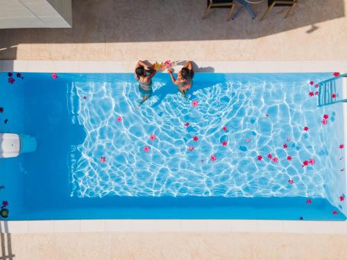 two people are playing in a swimming pool at サンメール座間味 in Zamami