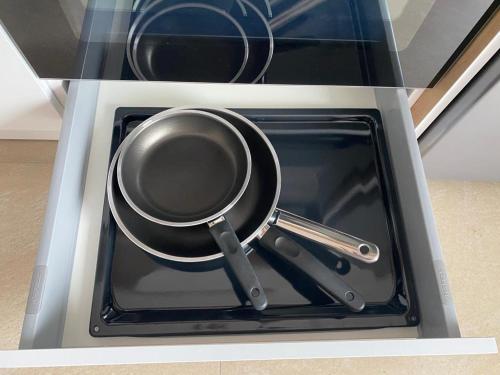 a frying pan and utensils sitting in a stove at LadyDi apartman in Banja Koviljača