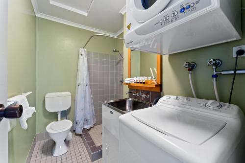 a washing machine in a bathroom with a sink at Alpine Mountain View 18 - 4BR l Mountain Views l Swimming Pool l Air-Con l WiFi in Jindabyne