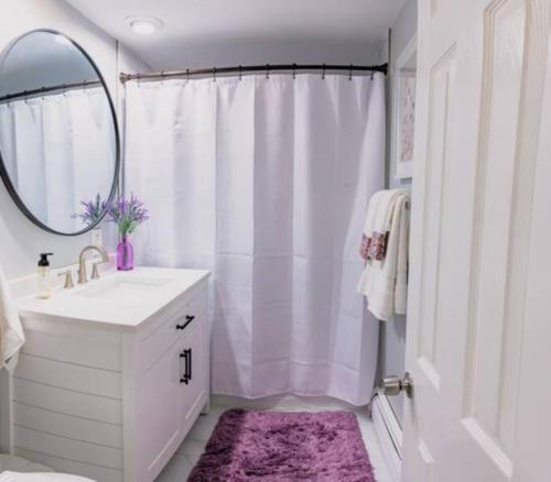 a white bathroom with a sink and a mirror at New Beautiful Condo In Bayonne near NYC. in Bayonne