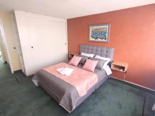 波哥大的住宿－Innovar Casa Hostal，卧室配有一张带粉红色枕头的大床