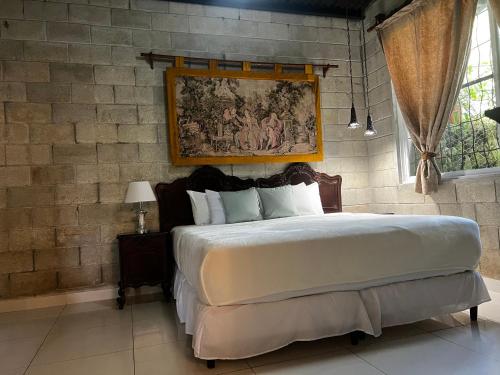 a bedroom with a large bed with a painting on the wall at Casa Madre Tierra in Valle de Anton