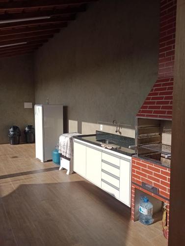 a kitchen with a counter and a sink and a refrigerator at Espaço Cris in Pindamonhangaba