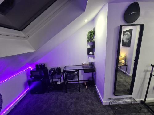 沃特福德的住宿－Hornet's Hideout，紫色的客房配有一张桌子和一面镜子