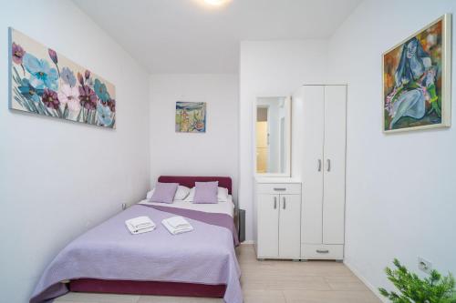 a white room with two beds and a door at Isaura Apartments in Dubrovnik