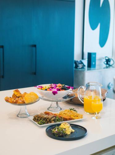a table with plates of food and glasses of orange juice at Black Urchin Boutique Resort in Belford Estates