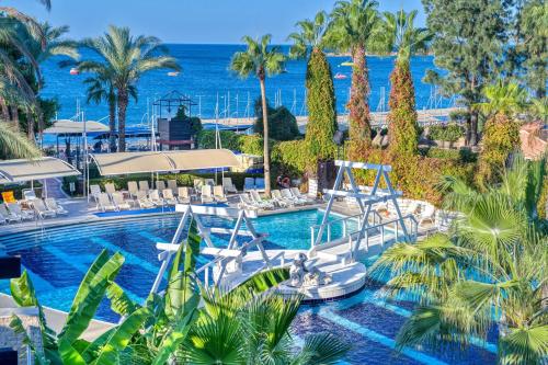 a resort swimming pool with a view of the ocean at Sealife Buket Resort & Spa Hôtel 5 étoiles in Antalya
