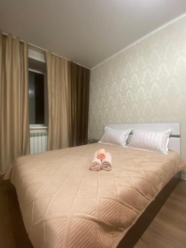 Комфортабельные - Уютные квартиры в городе Костанай (Плаза) في كوستاناي: غرفة نوم مع سرير مع اثنين من الكعك عليه