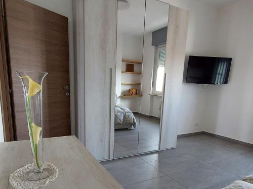 a room with a mirror and a vase on a table at Sesto Piano Apartment in Asti