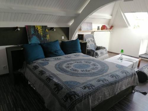 a bedroom with a large bed with blue pillows at Comfortable country house in Saint-Beauzély