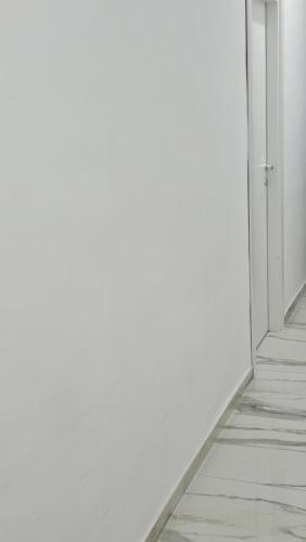 an empty corridor with an open door and white walls at HOTEL CRISARI in Naples