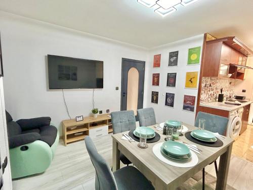 a living room with a table and chairs and a television at Best Family Apartment in Varna City