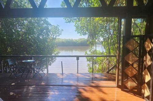 a screened in porch with a view of a lake at Willo's Treehouse in Escuintla