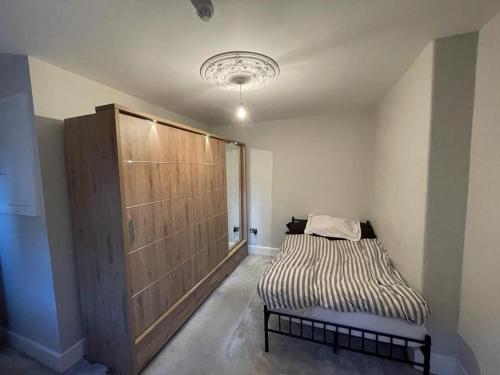 una camera con un letto e un grande armadio in legno di Beautiful Flat, Perfect Location in Newcastle a Jesmond