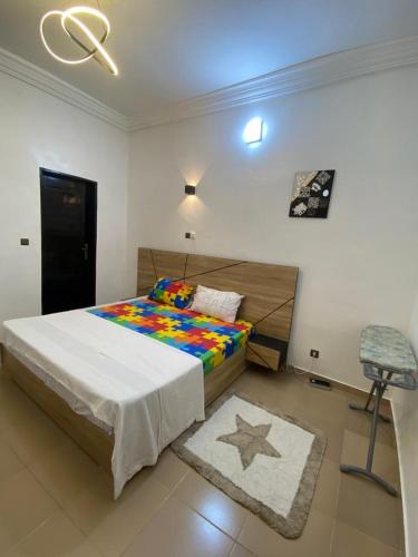 a bedroom with a large bed and a chair at Charly Cabanadeluxe in Cotonou