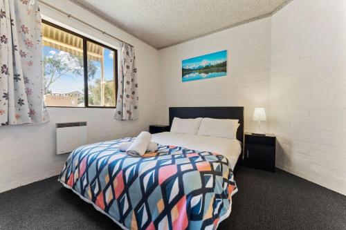a bedroom with a bed and a window at Alpine Mountain View 39 Ground Floor 3 Bedroom Unit in Jindabyne