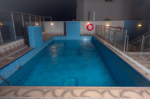 a large swimming pool at night in a building at Areen Hotel in Jeddah