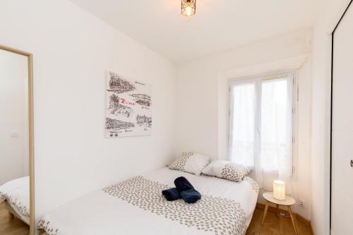 une chambre blanche avec un lit et une fenêtre dans l'établissement Sweet Azur - Host Provence, au Cannet