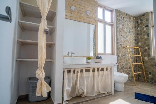 a bathroom with a sink and a toilet at Casa Azul Departamentos frente al mar in Máncora