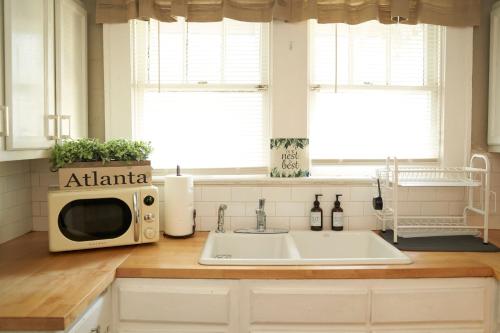um balcão de cozinha com um micro-ondas e um lavatório em Atl Layover #2 - So Fresh And So Clean em Atlanta