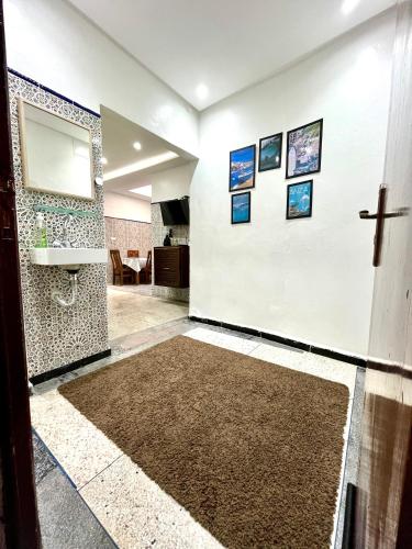 a hallway with a white wall with pictures on it at Agadir House 2 in Agadir