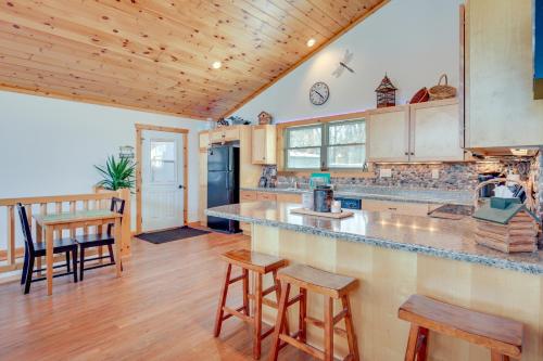 a kitchen with a counter top and wooden ceilings at Lakefront Tomahawk Getaway with Deck and 2 Fireplaces! in Tomahawk