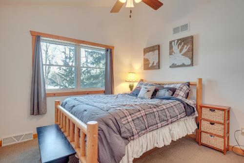 a bedroom with a bed and a window at Lakefront Tomahawk Getaway with Deck and 2 Fireplaces! in Tomahawk