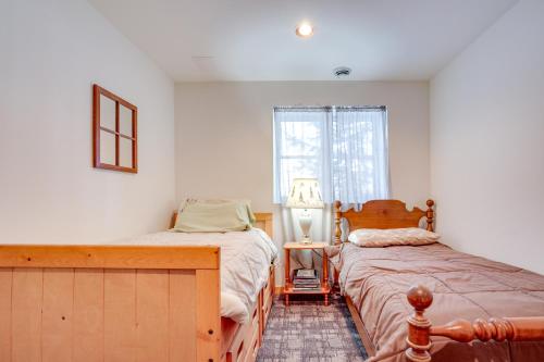 a bedroom with two beds and a window at Lakefront Tomahawk Getaway with Deck and 2 Fireplaces! in Tomahawk