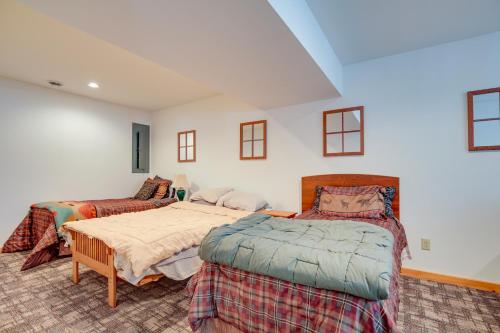 a bedroom with two twin beds and a couch at Lakefront Tomahawk Getaway with Deck and 2 Fireplaces! in Tomahawk