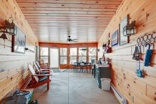 a cabin with wooden walls and a kitchen and a dining room at Lakefront Tomahawk Getaway with Deck and 2 Fireplaces! in Tomahawk