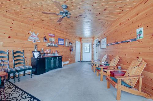 a dining room with a ceiling fan and wooden walls at Lakefront Tomahawk Getaway with Deck and 2 Fireplaces! in Tomahawk