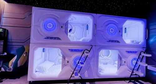 a purple room with four beds in it at flor hostel capsules in Madrid