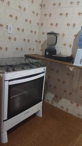 a kitchen with a stove top oven in a room at Casa de Praia - Alcobaça-BA - em frente ao Condomínio Gaivotas in Alcobaça