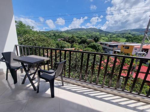 balcón con mesa, sillas y vistas en Hotel la casona de Wiky en Guaduas