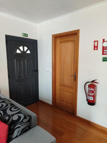a room with a black door and a fire hydrant at Delfina`s House in Machico
