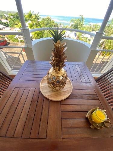 a wooden table with a pineapple on top of a balcony at Ti iguane in La Trinité