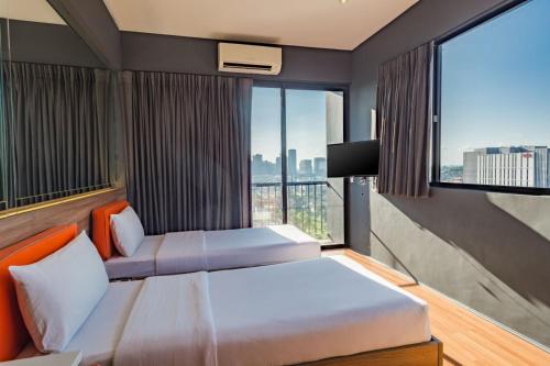 a hotel room with two beds and a large window at Azumi Boutique Hotel in Manila