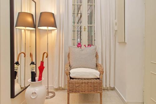 una stanza con una sedia e due lampade e un ombrello di CASA GIULIANA - 3BR 2BATH, 2nd floor of historic mansion with lift and doorman, comfortable, chic, family friendly, 600 meters from Vatican & Ottaviano metro, quietest area of P R A T I wealthy, secure, accessible district - Warm guest care in 4 languages a Roma