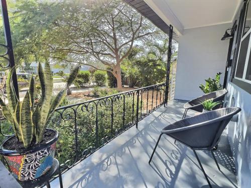 a balcony with two chairs and a plant at Urban Get-A-Way in Historic St Pete EAT SHOP PLAY in St. Petersburg