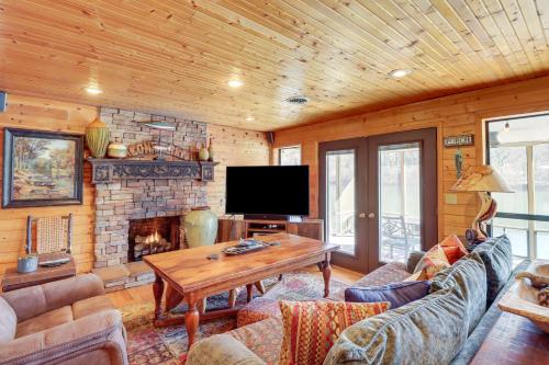 a living room with a table and a fireplace at Spacious Cabin with Private Dock on White River! in Flippin