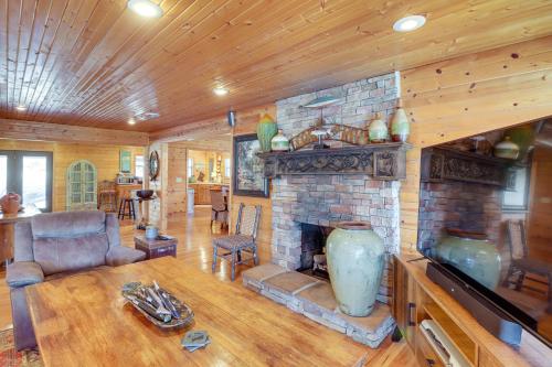 a living room with a stone fireplace in a house at Spacious Cabin with Private Dock on White River! in Flippin