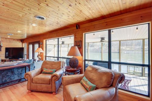 a living room with two chairs and a television at Spacious Cabin with Private Dock on White River! in Flippin