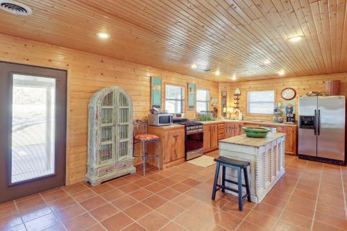a large kitchen with wooden walls and a refrigerator at Spacious Cabin with Private Dock on White River! in Flippin
