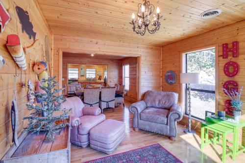 a living room with chairs and a chandelier at Spacious Cabin with Private Dock on White River! in Flippin