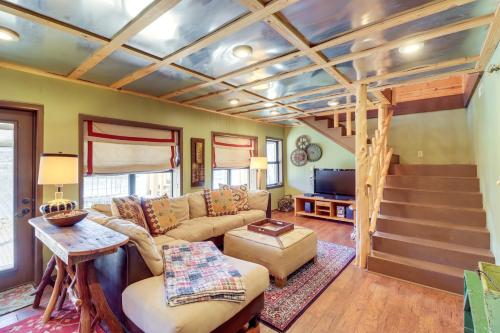 a living room with a couch and a staircase at Spacious Cabin with Private Dock on White River! in Flippin